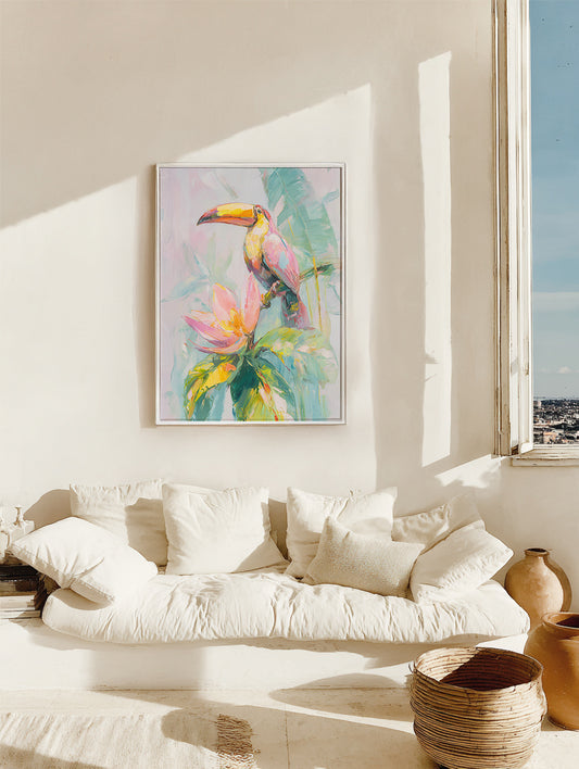 Framed artwork of a toucan on a flower in a living room with a white sofa and window view.