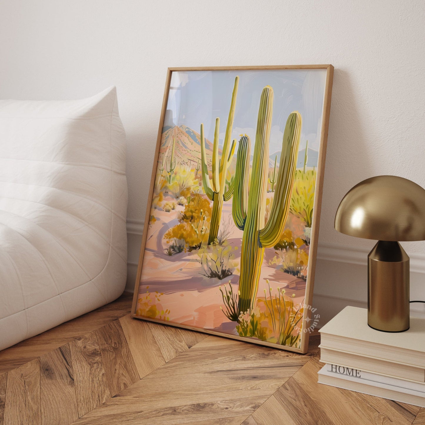 Framed artwork of a desert scene with cacti in a beedroom floor