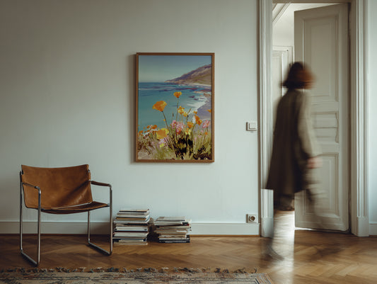Brown leather chair and stack of books in a room with a large framed picture on the wall.