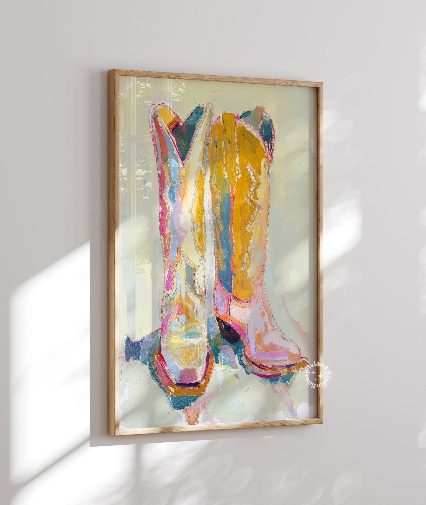 Colorful abstract art of cowgirl boots in a wooden frame on a white wall.