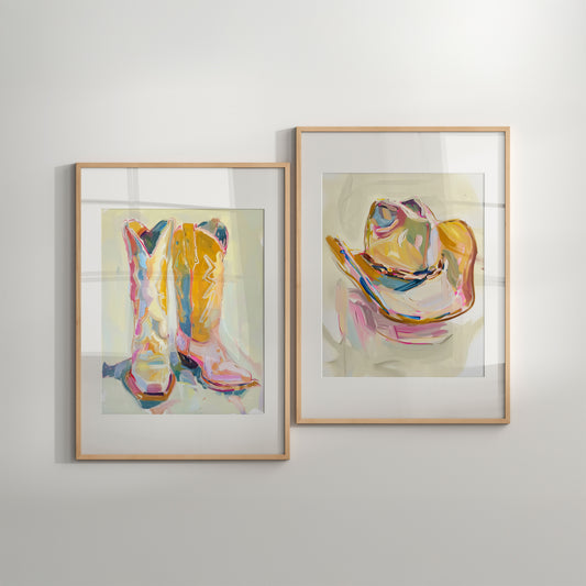 Two framed artworks of colorful cowboy boots and hat on a light gray wall.