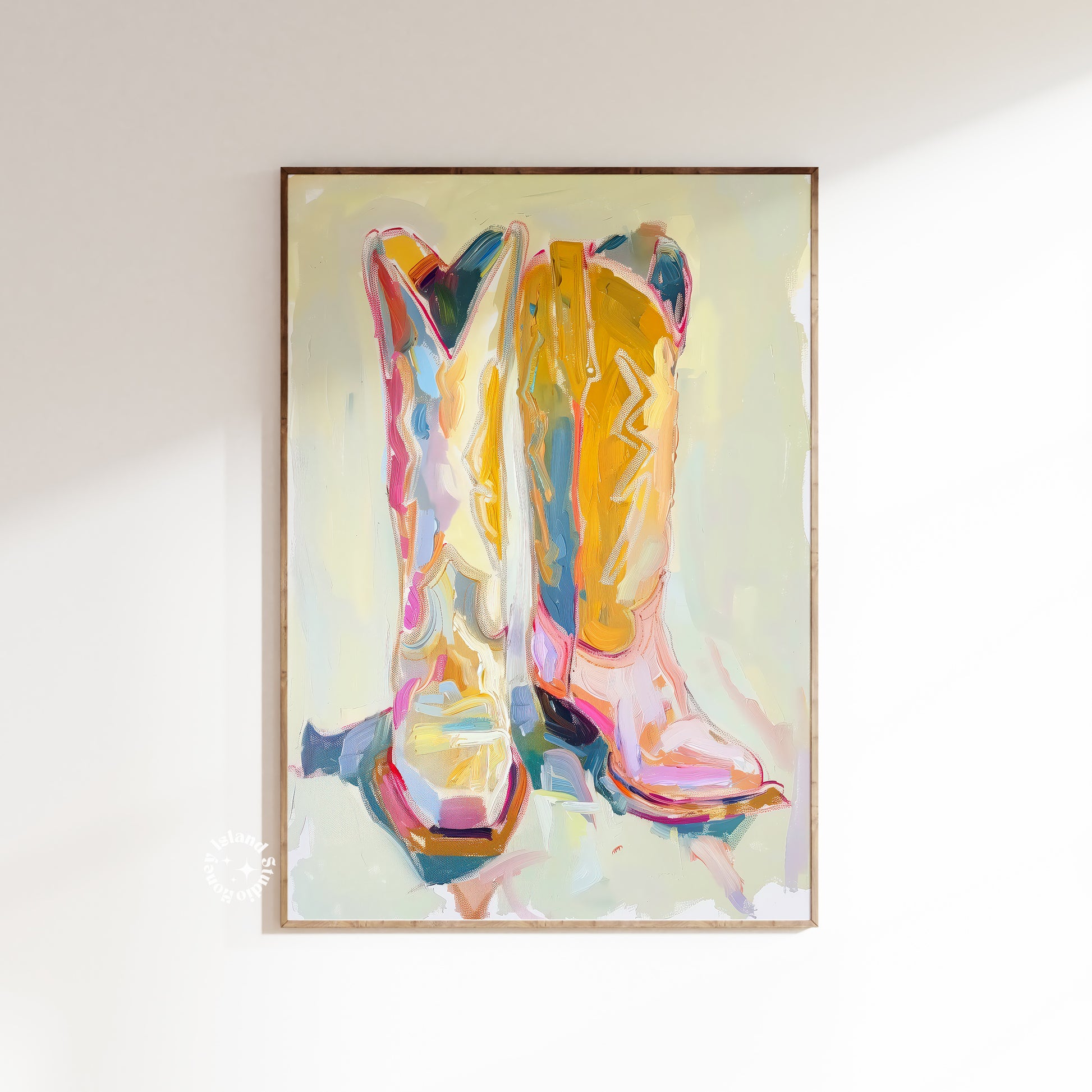 Framed abstract artwork of colorful cowboy boots on a white wall.