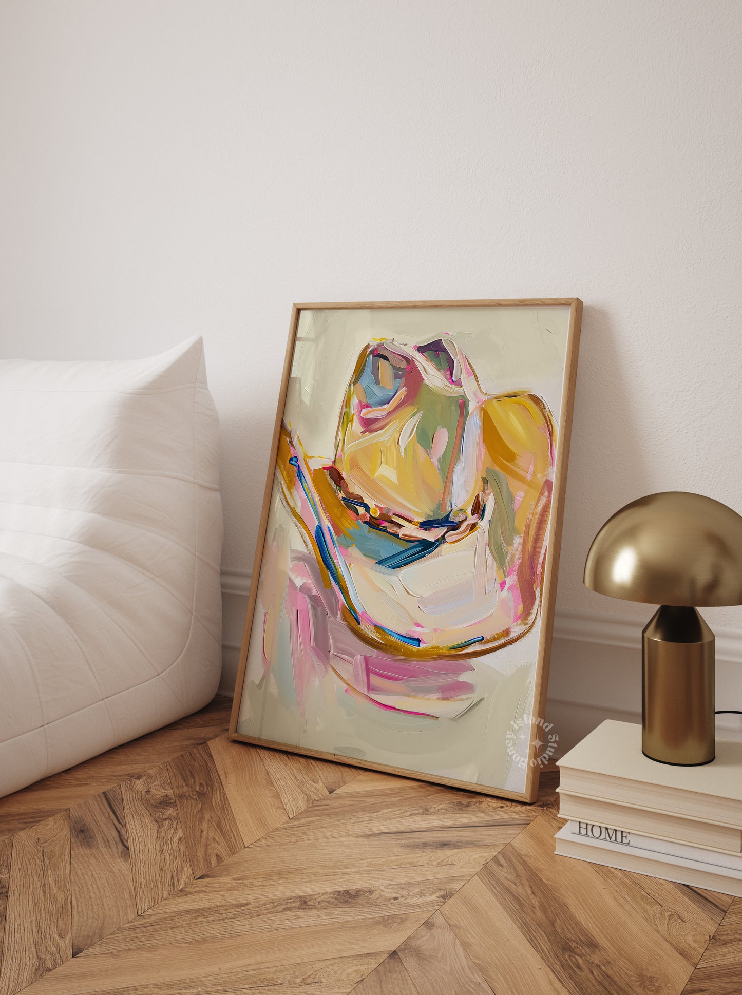 Cowgirl hat painting in a wooden frame on a wall next to a white sofa and gold lamp.