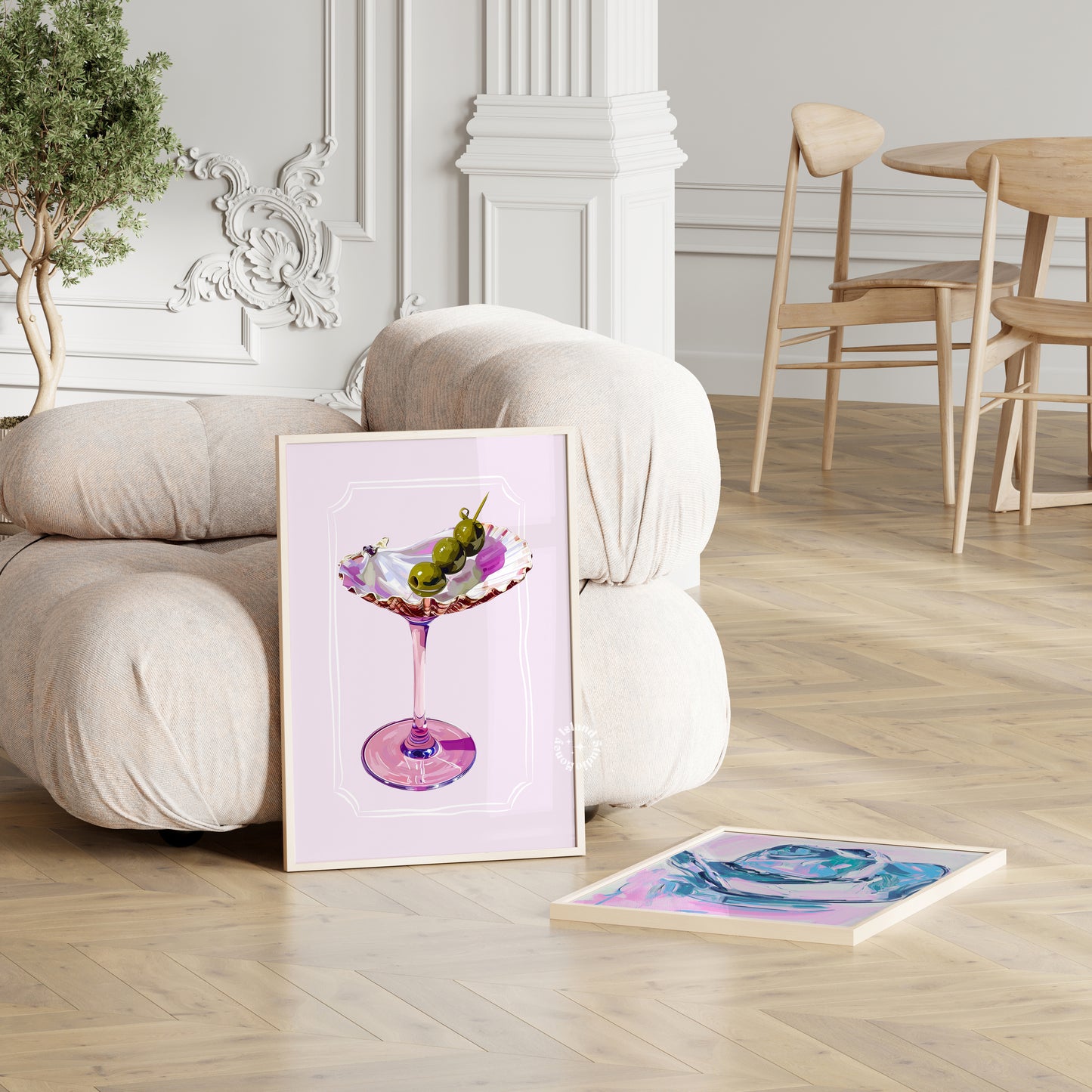 Framed artwork of a cocktail on a white surface with a room in the background