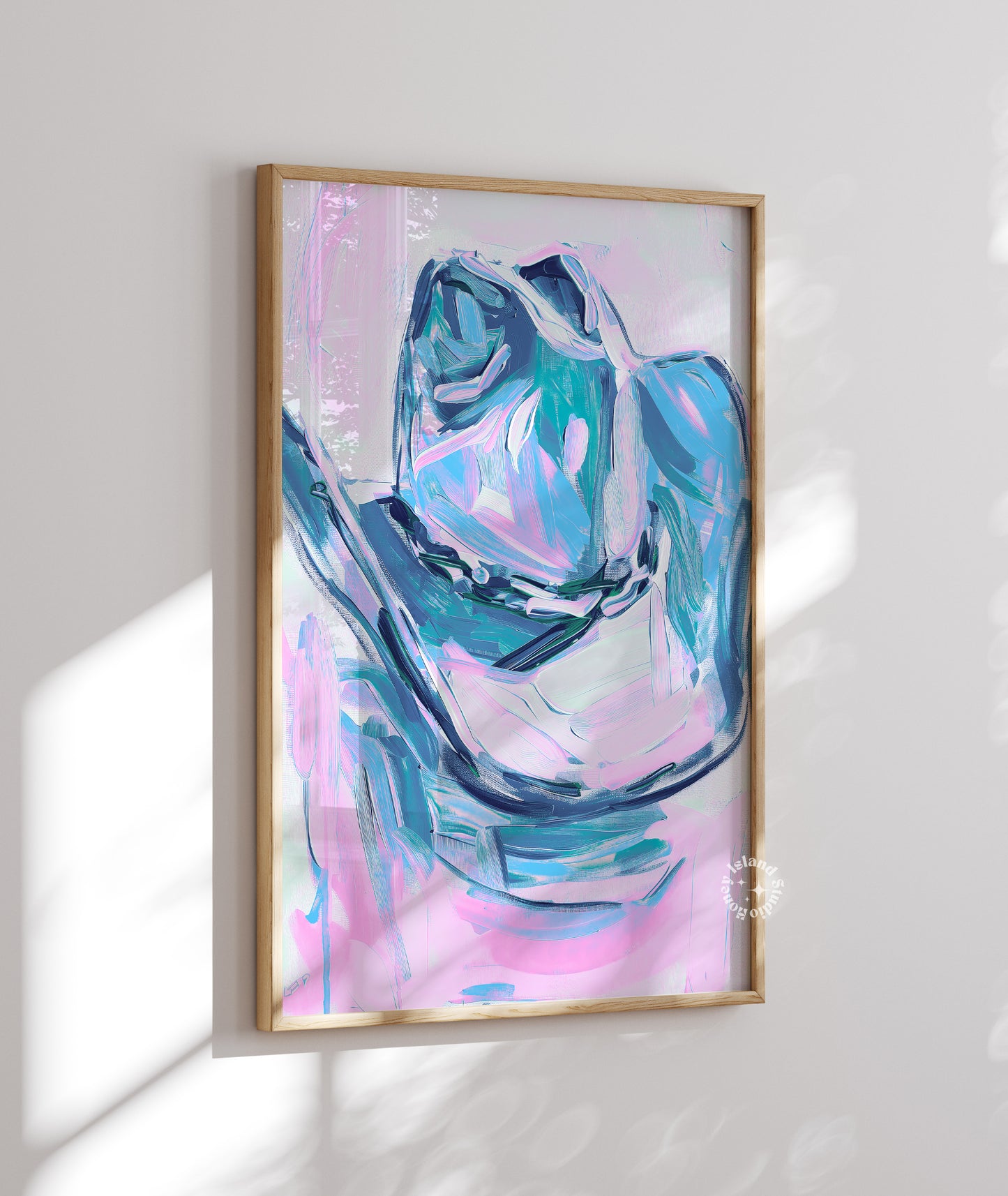 Framed abstract art print with blue and pink colors on a white wall