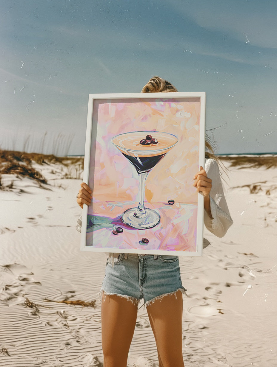 Person holding a framed painting of a cocktail on a beach