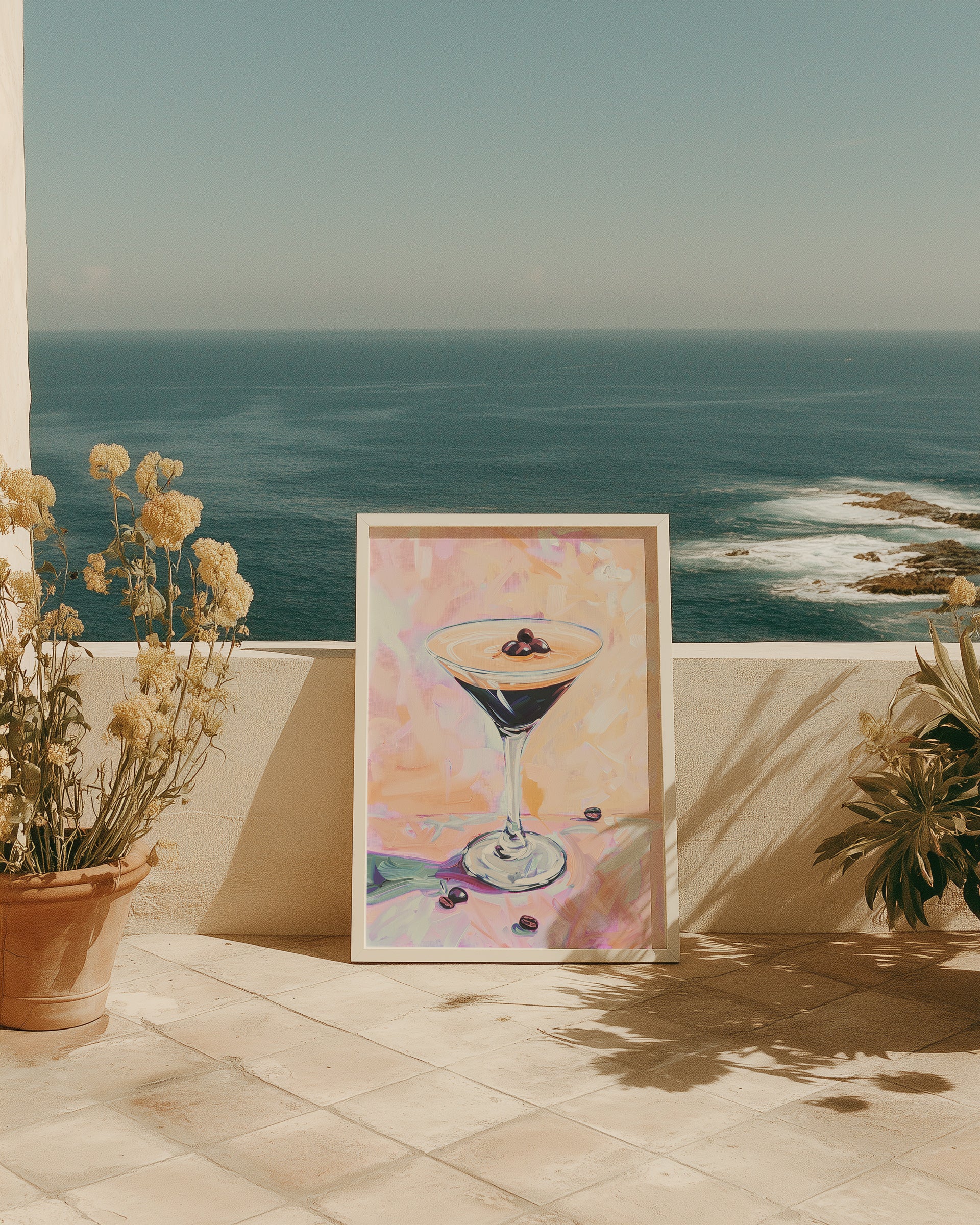 Framed artwork of a cocktail on a patio with ocean view