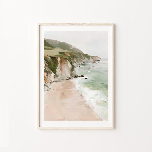 Framed artwork of a coastal landscape with cliffs and beach on a white wall.