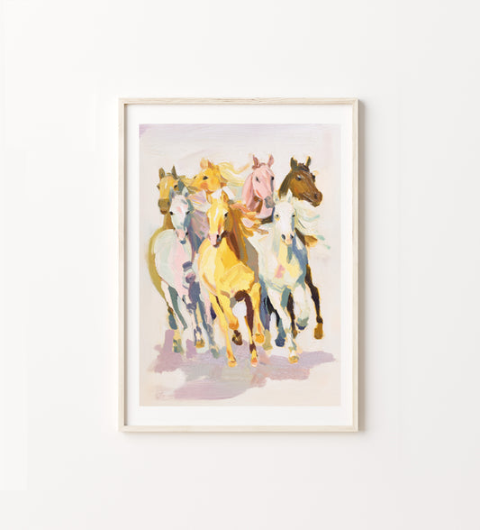 Framed artwork of colorful horses on a white wall