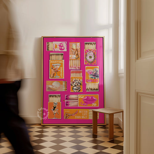 Framed collage of vintage matchbox labels on a pink background in a room with checkered floor.