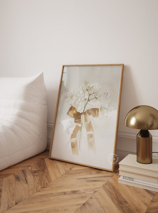 Framed artwork with a floral design and gold frame on a wooden floor.