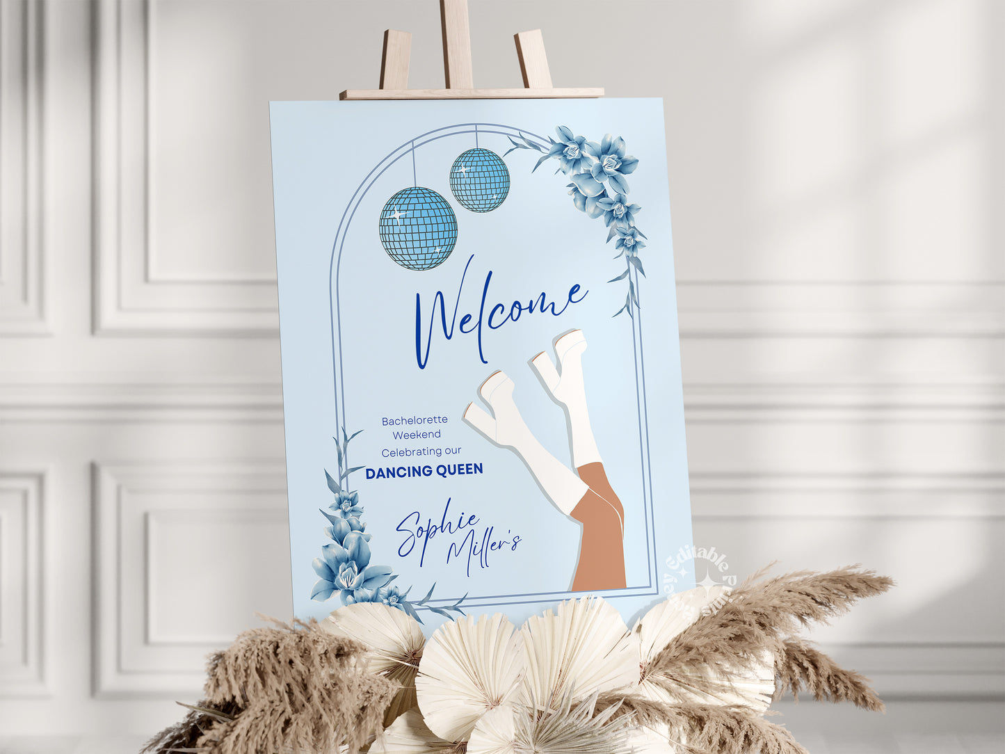 Light blue Mamma Mia-themed welcome sign for a bachelorette weekend party, elegantly displayed on an easel in a sunlit room with a white wall background. The sign features a Mediterranean-inspired design, perfect for a fun and stylish celebration.