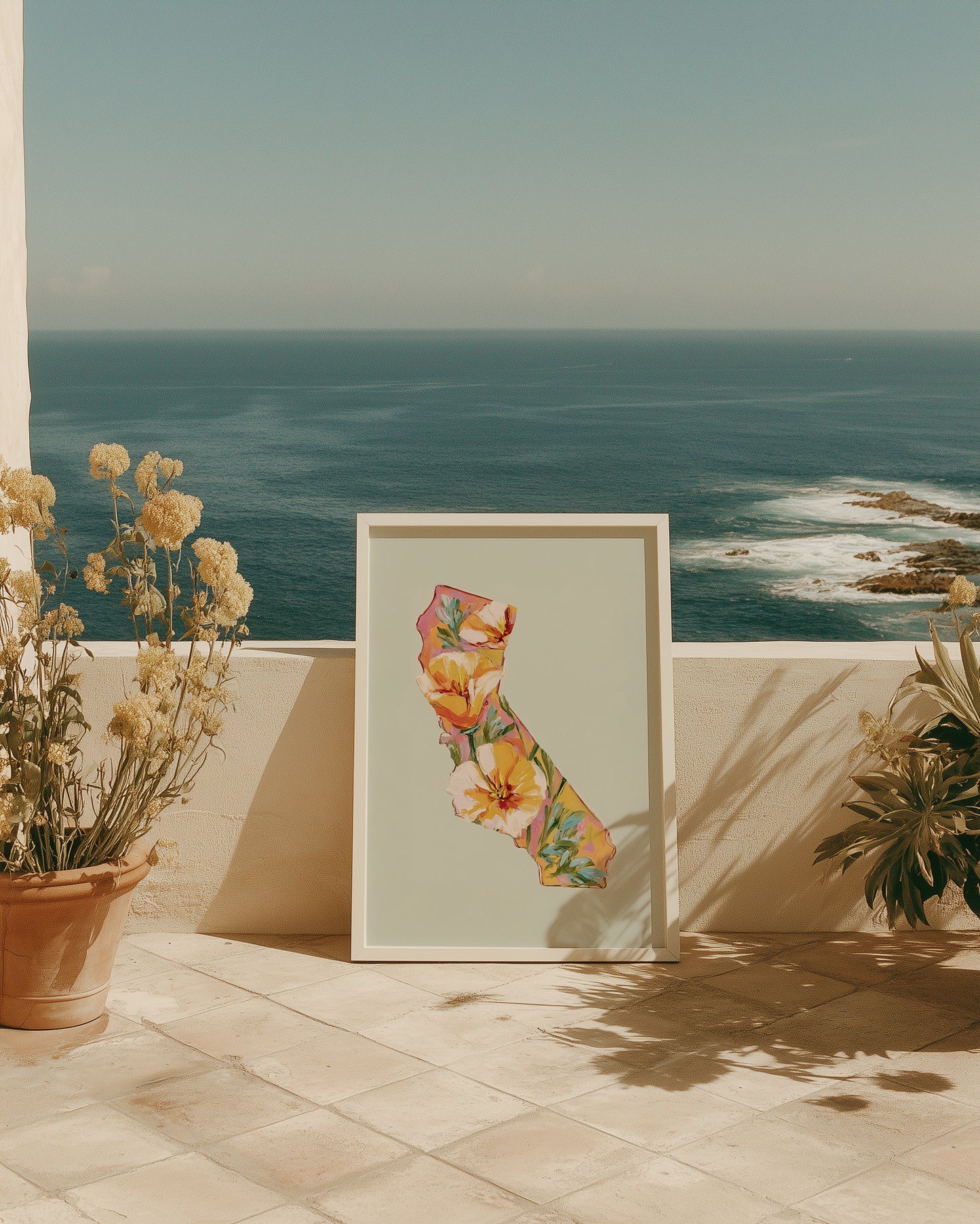 Framed floral artwork on a patio with ocean view