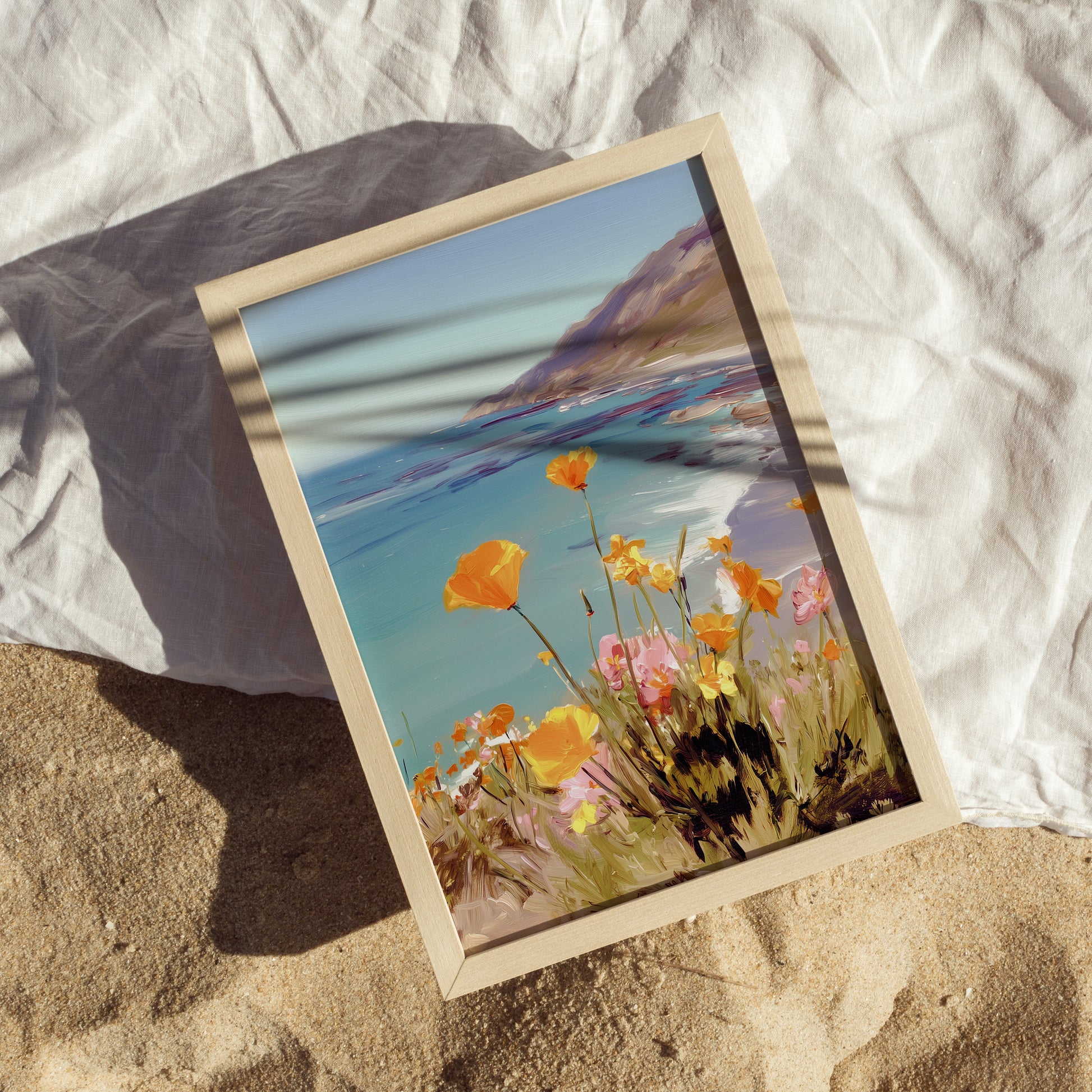Framed artwork of a beach scene with flowers on a the sand on the beach