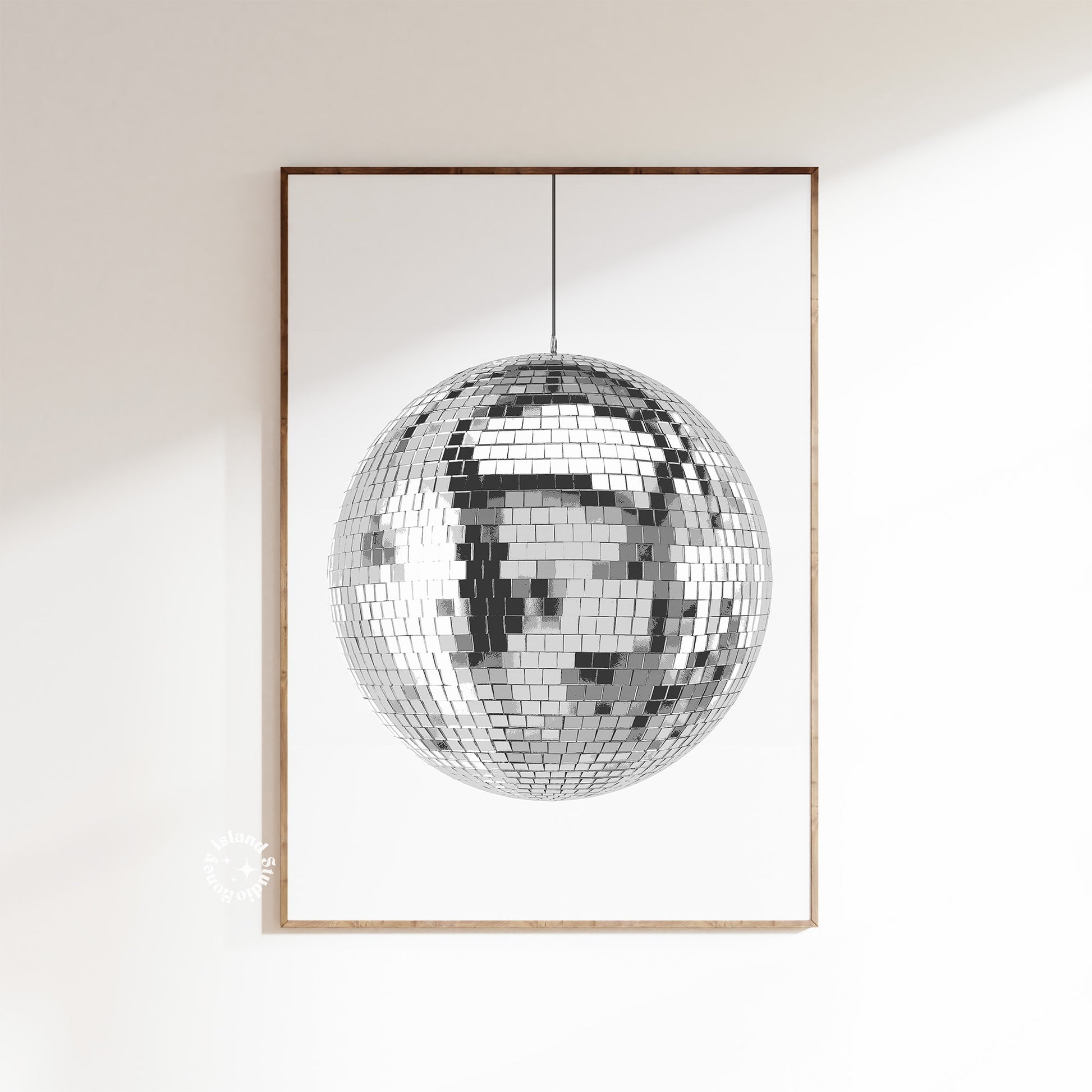 A disco ball poster with a white and silver design, depicting a reflective mirror ball, framed and displayed on a wall.