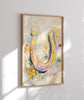Colorful horseshoe artwork in a wooden frame on a white wall