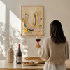 Woman holding a glass of red wine in a room with a colorful horseshoe painting on the wall.