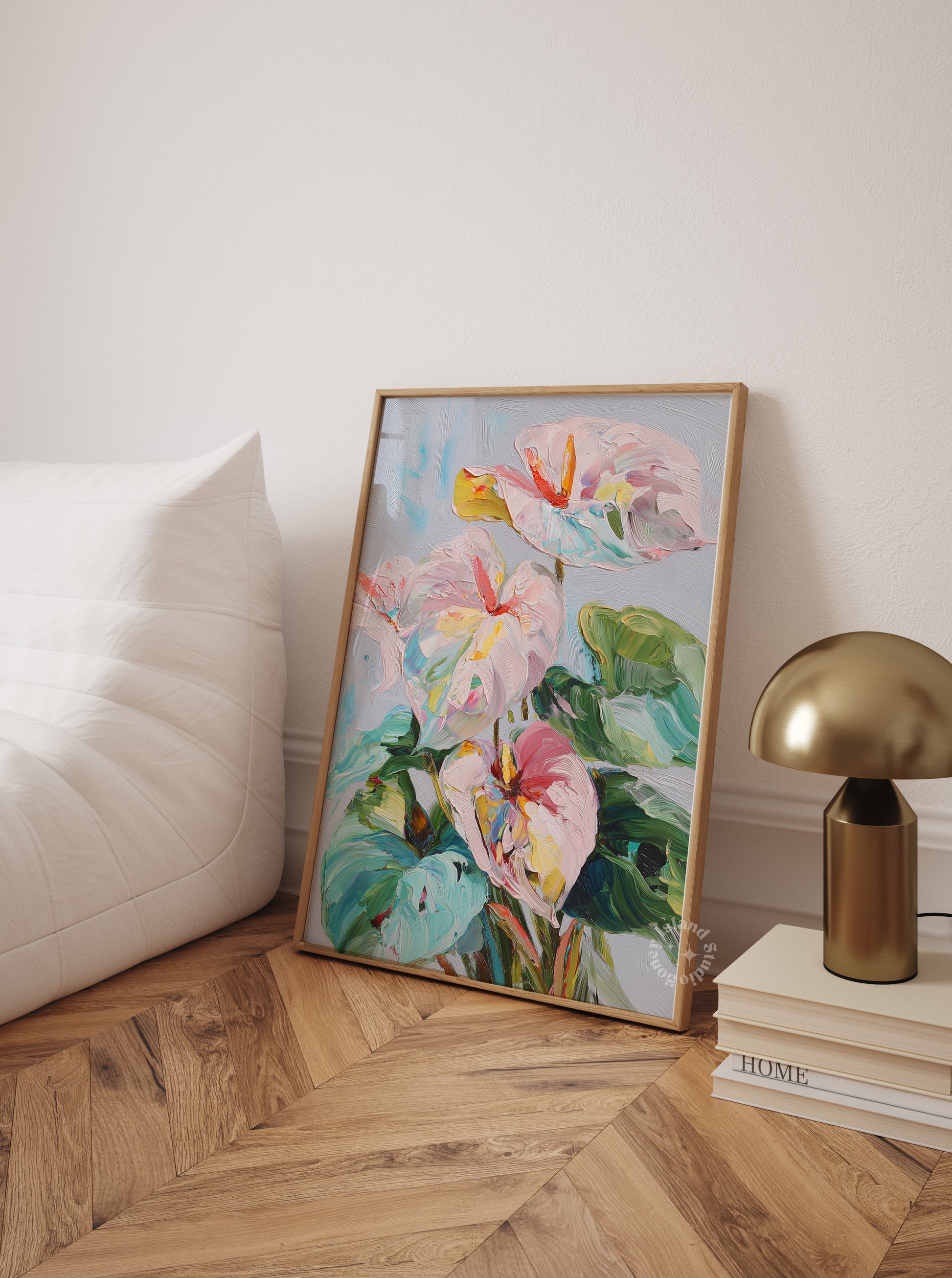 Framed floral artwork on a wall next to a white sofa and gold lamp.