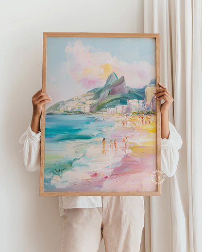 Person holding a framed watercolor painting of a beach scene with mountains.