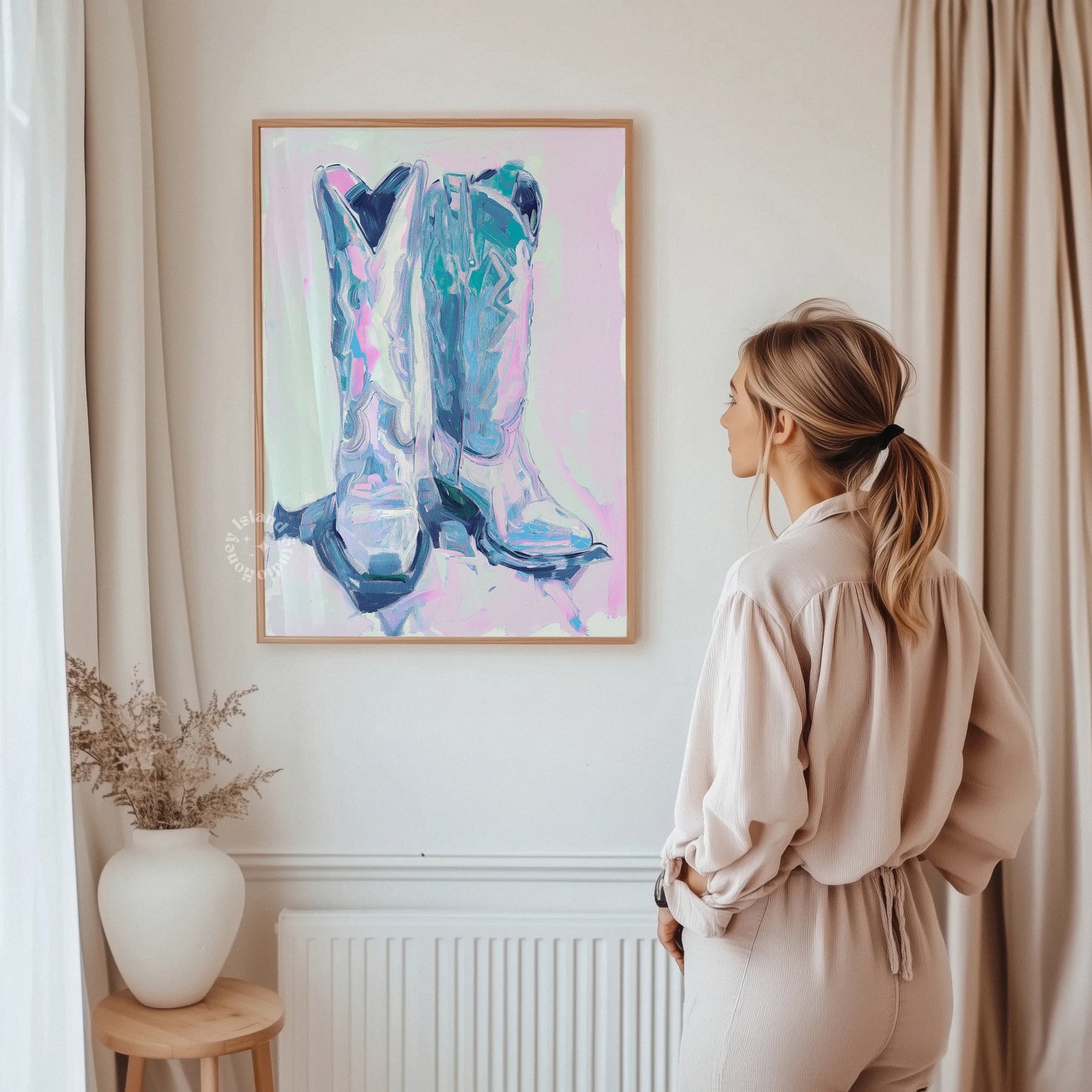 Woman standing in a room looking at a colorful abstract painting of cowboy boots on the wall.
