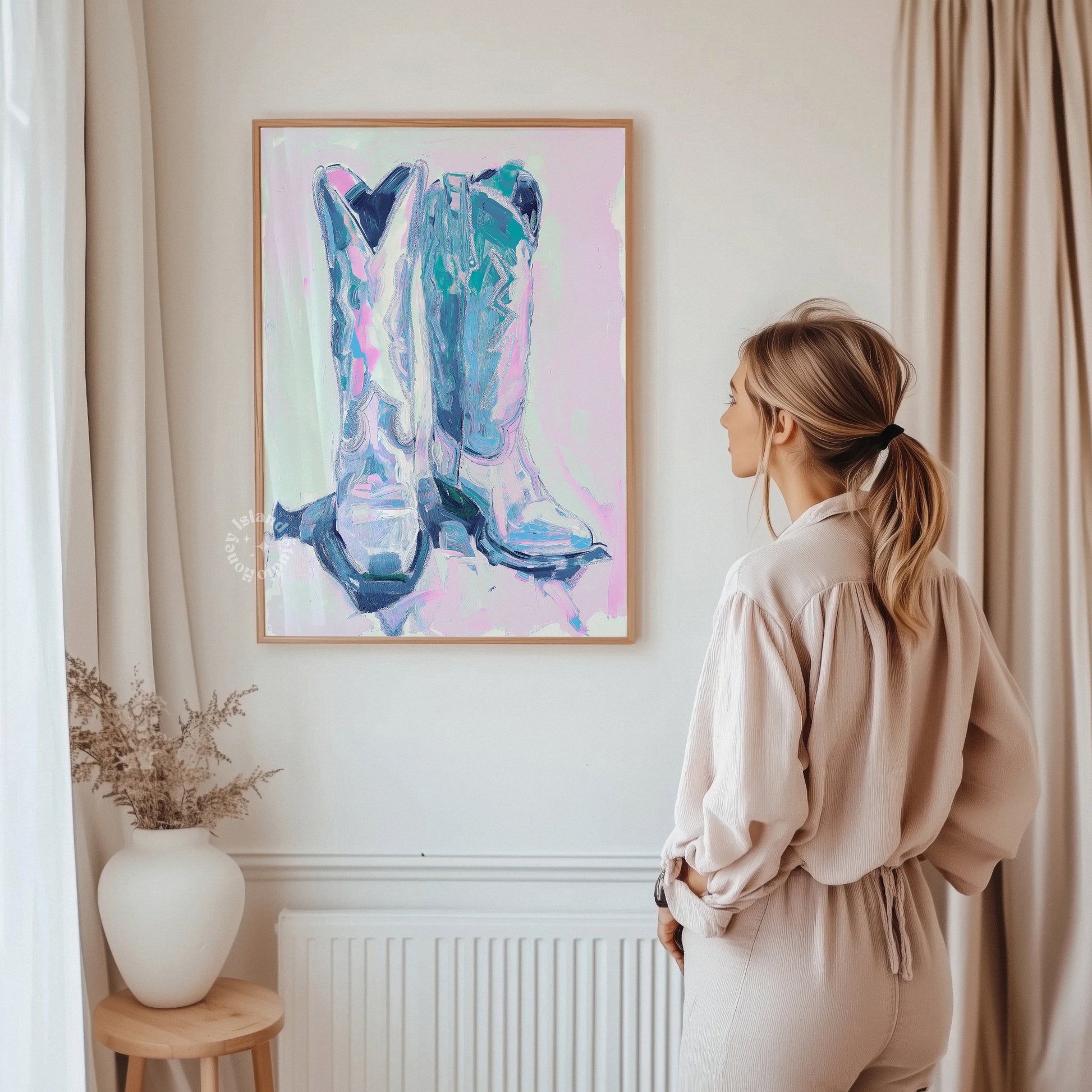 Woman standing in a room looking at a colorful abstract painting of cowboy boots on the wall.