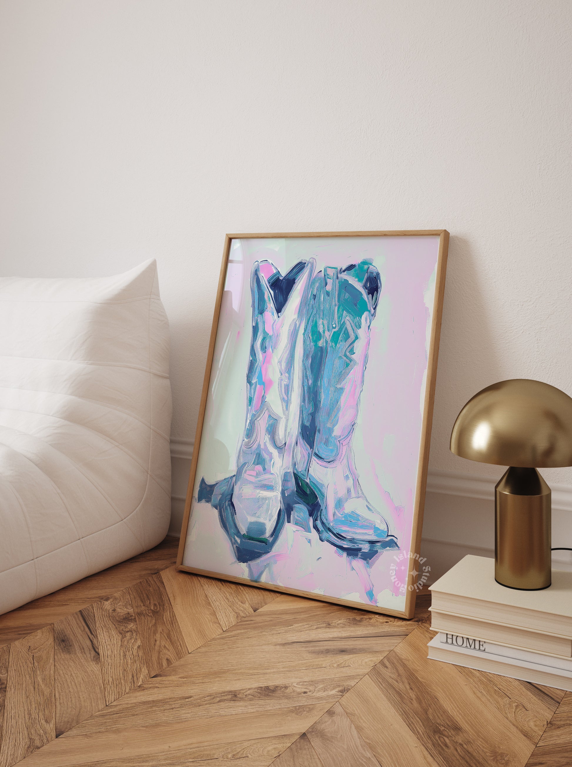 Framed abstract art piece on a side table with a lamp and books in a room.