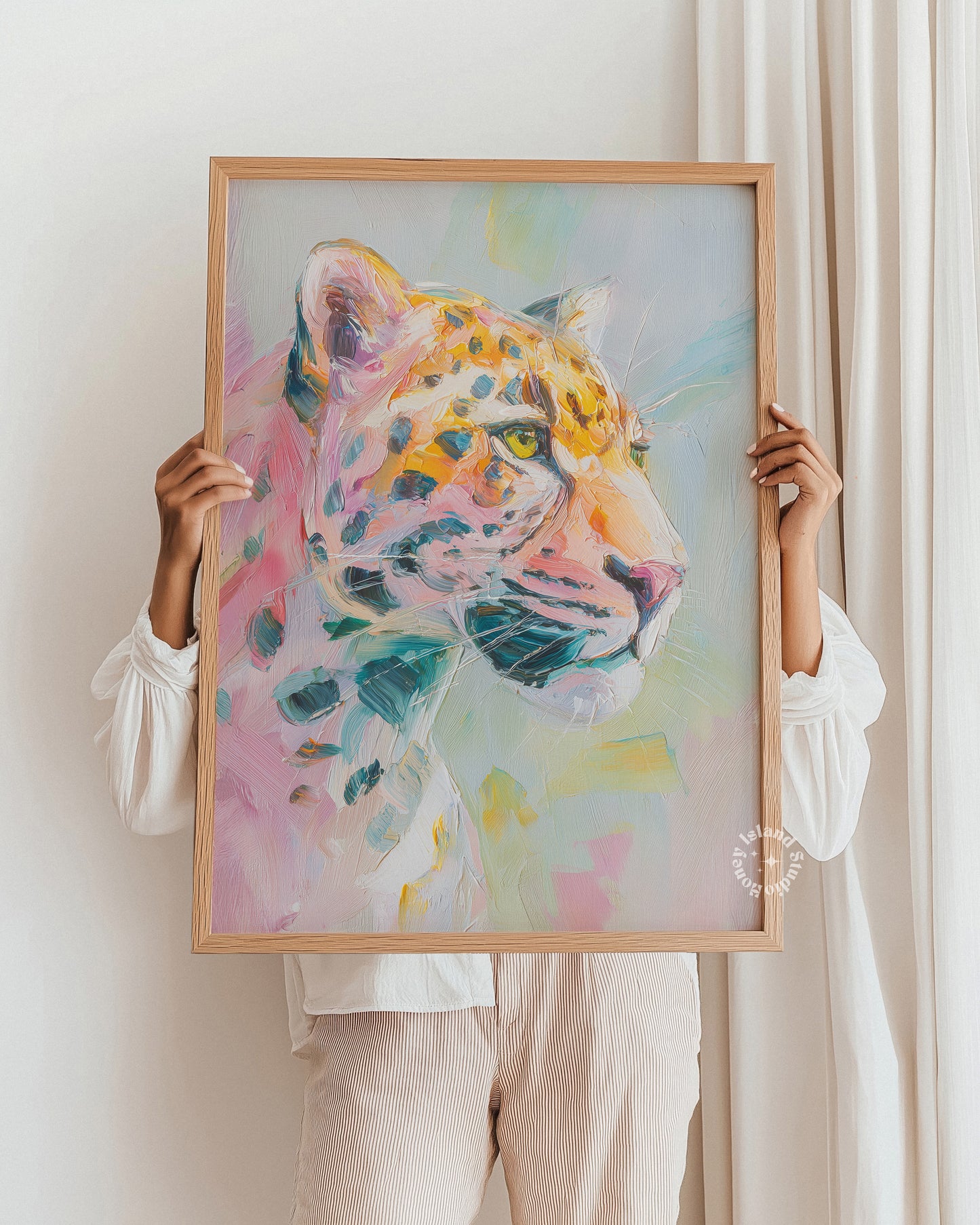 Person holding a colorful painting of a leopard in a wooden frame.