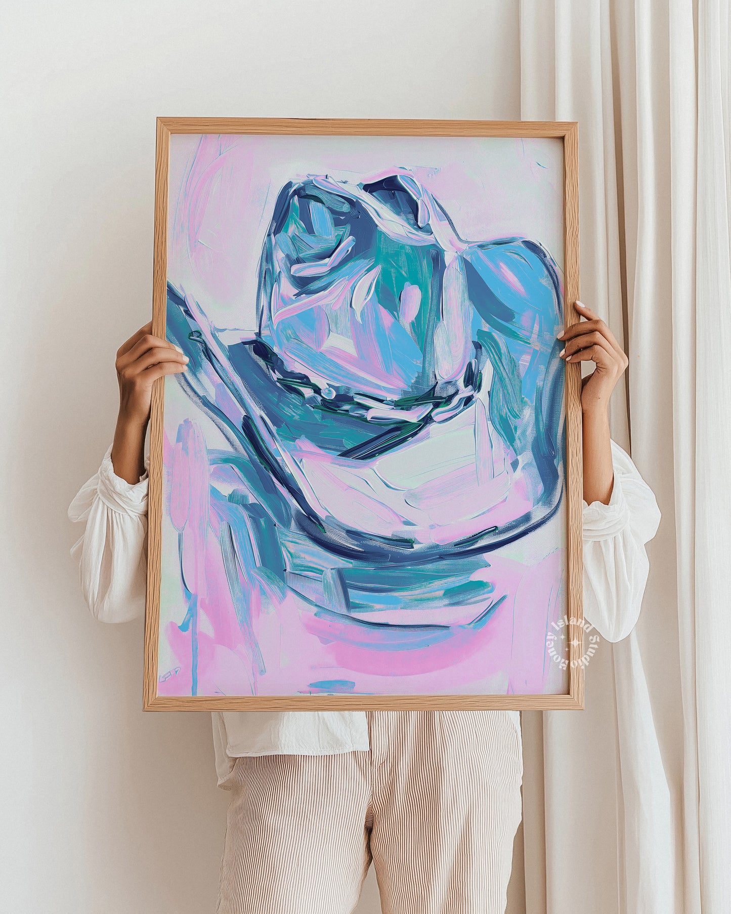 Person holding a framed abstract painting with a colorful design.