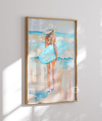 Framed artwork of a woman in a blue dress and white hat on a white wall.