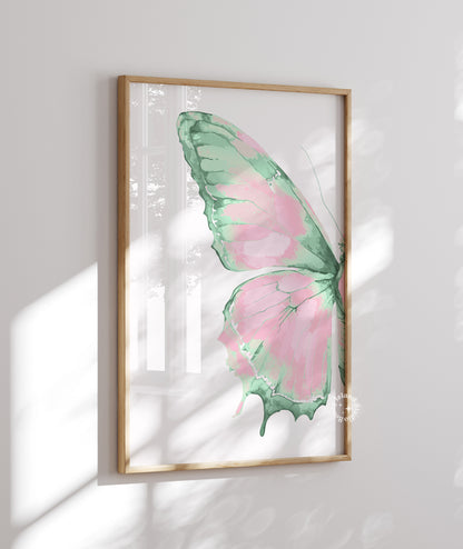 Framed artwork of a pink and green butterfly on a white wall