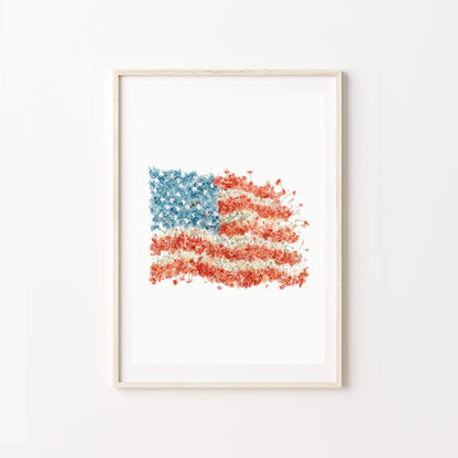 Framed artwork of an American flag with a watercolor texture on a white wall.