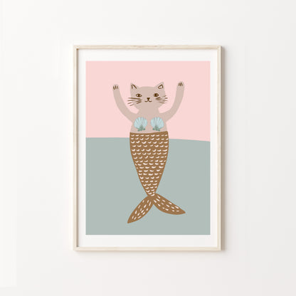 Framed artwork of a cat with a mermaid tail on a pink and blue background