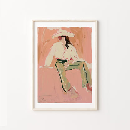 Framed artwork of a western woman cowgirl sitting on a pink background
