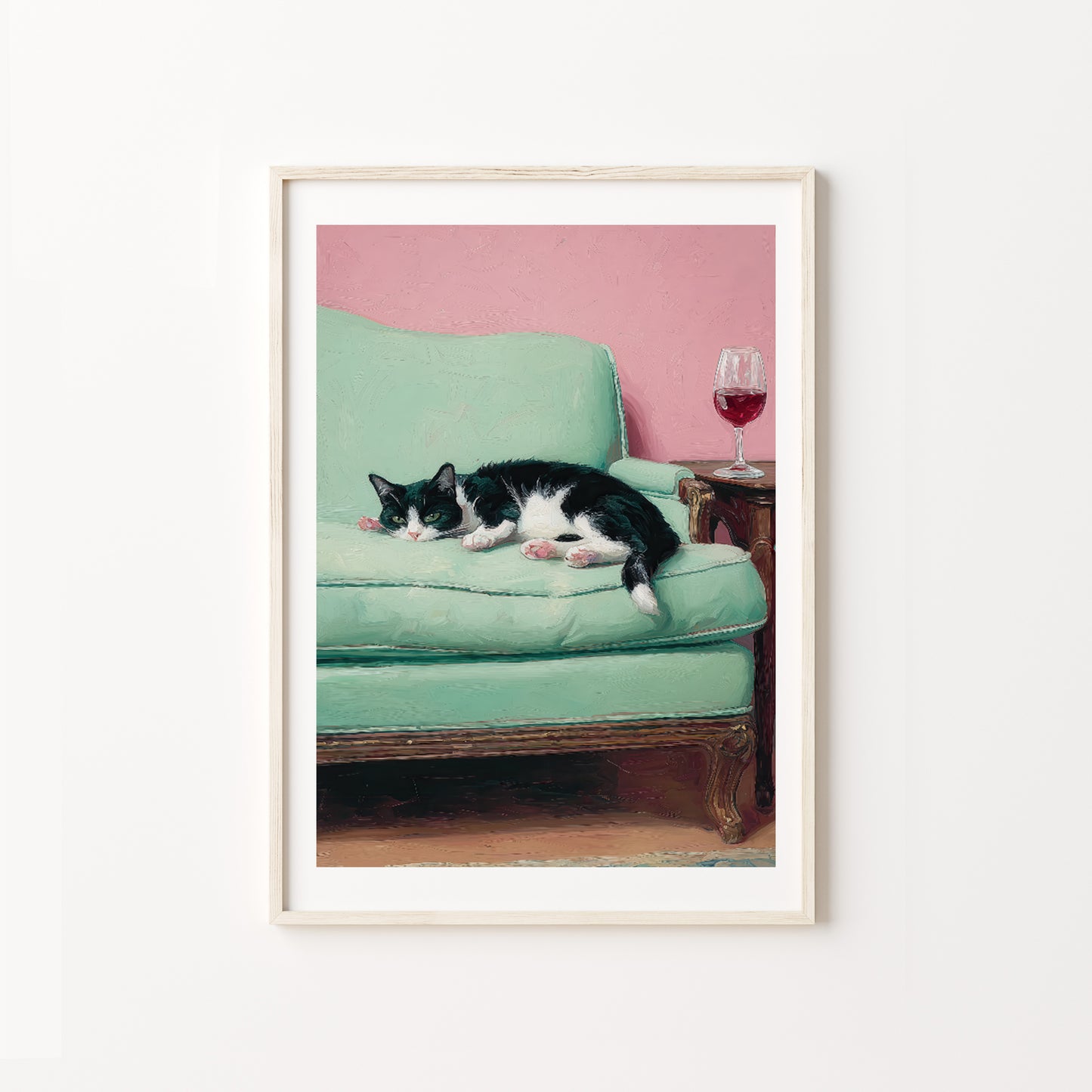 Framed artwork of a cat lying on a green couch with a pink wall in the background.