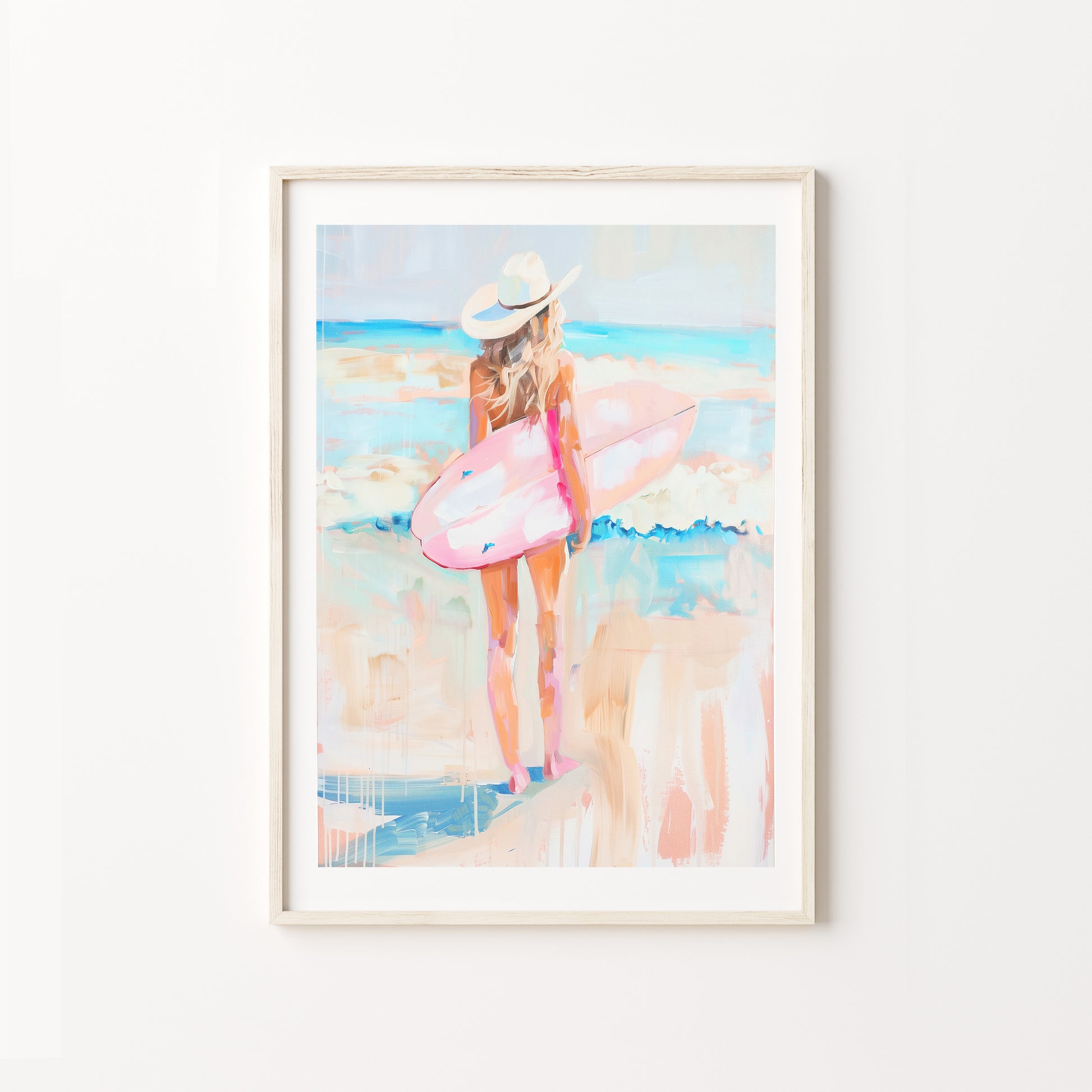 Framed artwork of a woman with a pink surfboard on a beach.