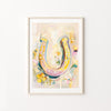 Colorful horseshoe artwork in a frame on a white wall