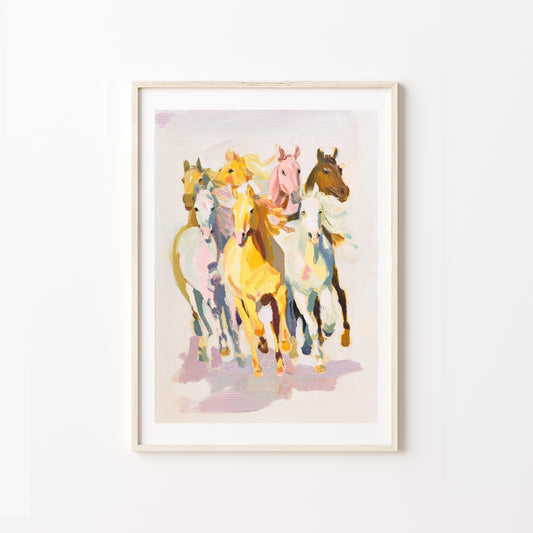 Framed artwork of colorful horses on a white wall