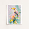 Framed artwork of a toucan on a branch with flowers and leaves.