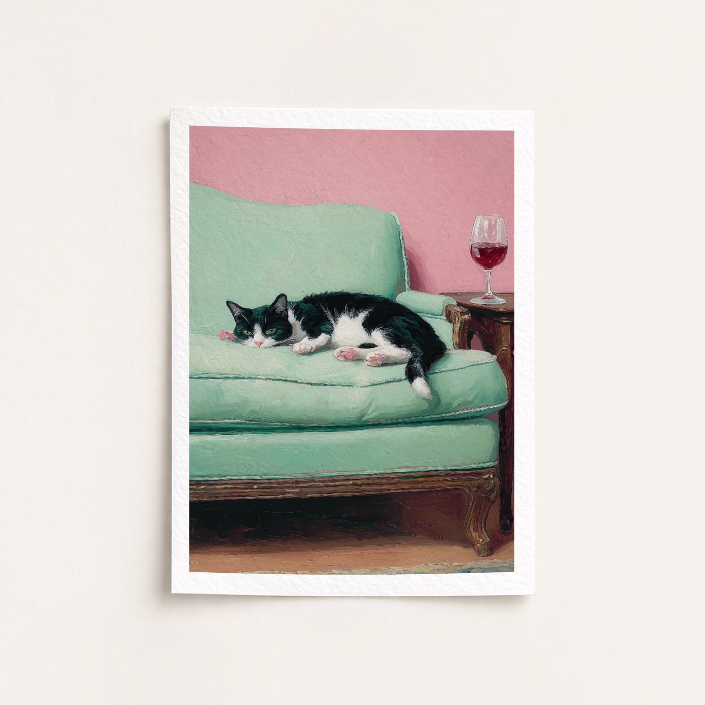 Cat lying on a green couch with a pink wall and wine glass in the background
