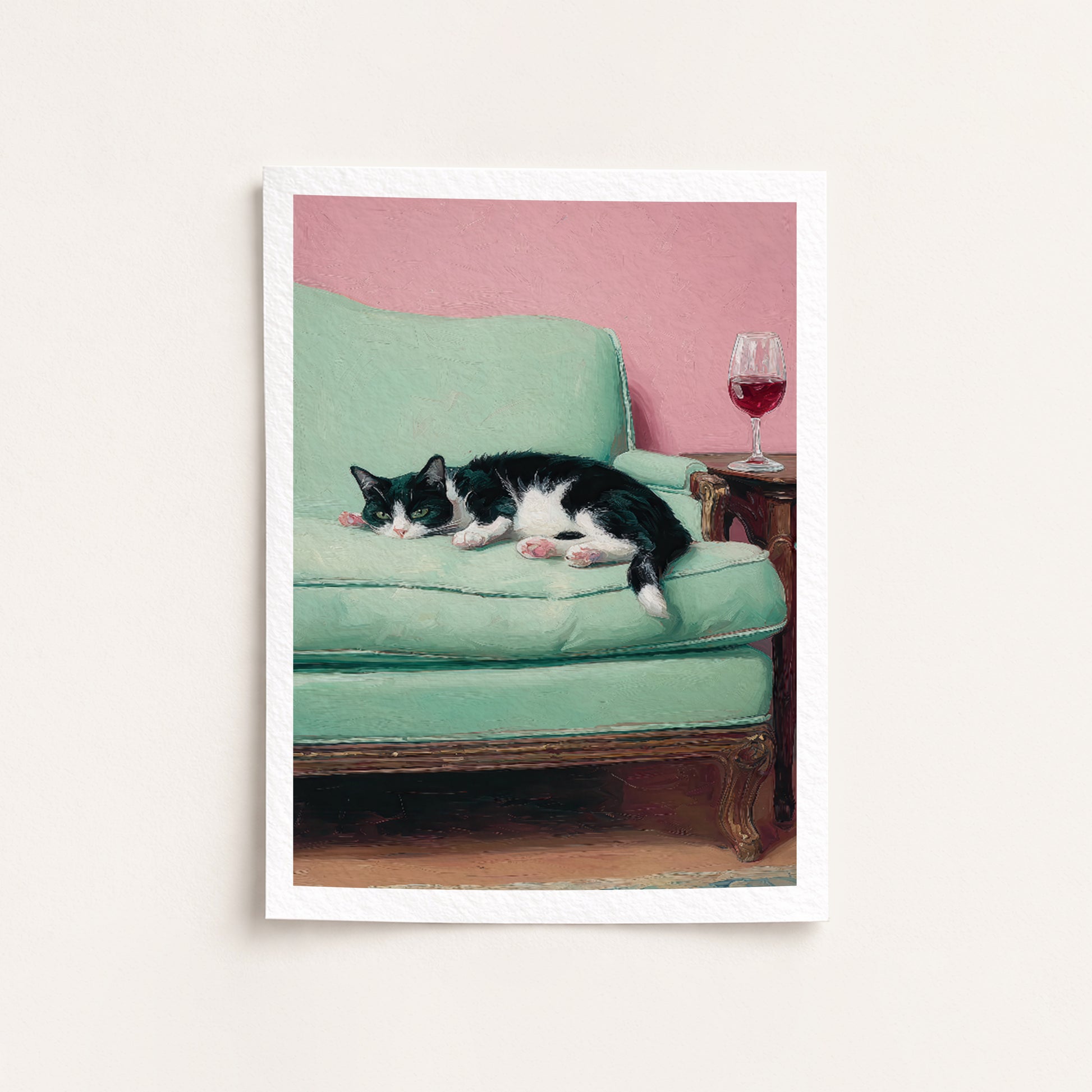 Cat lying on a green couch with a pink wall and wine glass in the background