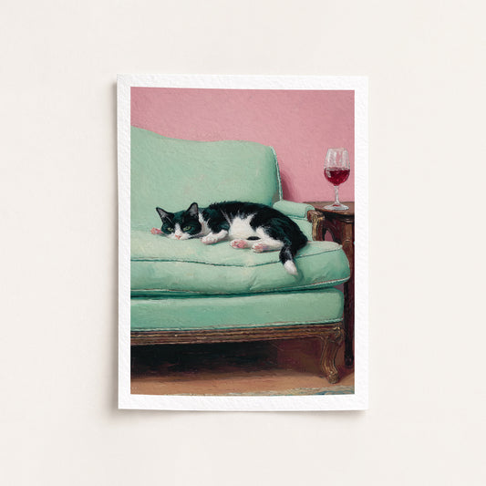 Cat lying on a green couch with a pink wall and wine glass in the background