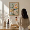 Woman holding a glass of red wine in a cozy room with a painting on the wall.