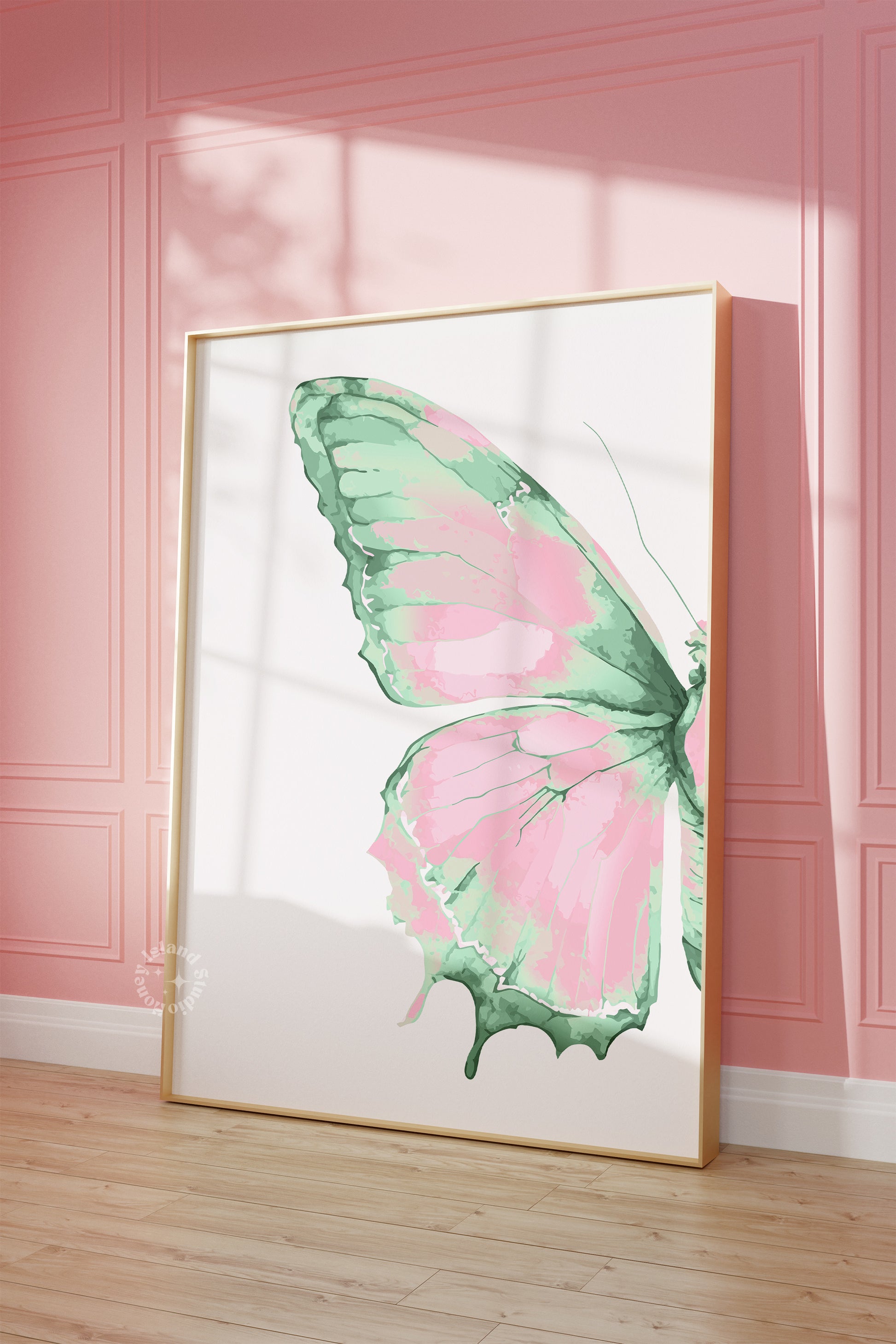 Framed artwork of a pink and green butterfly on a pink wall.