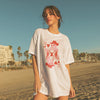 Woman wearing a white t-shirt with a graphic design on a beach