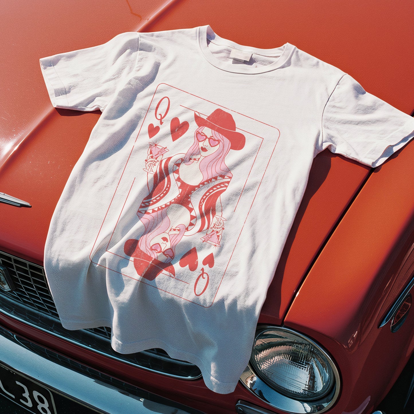 White t-shirt with red graphic design on a red vintage car