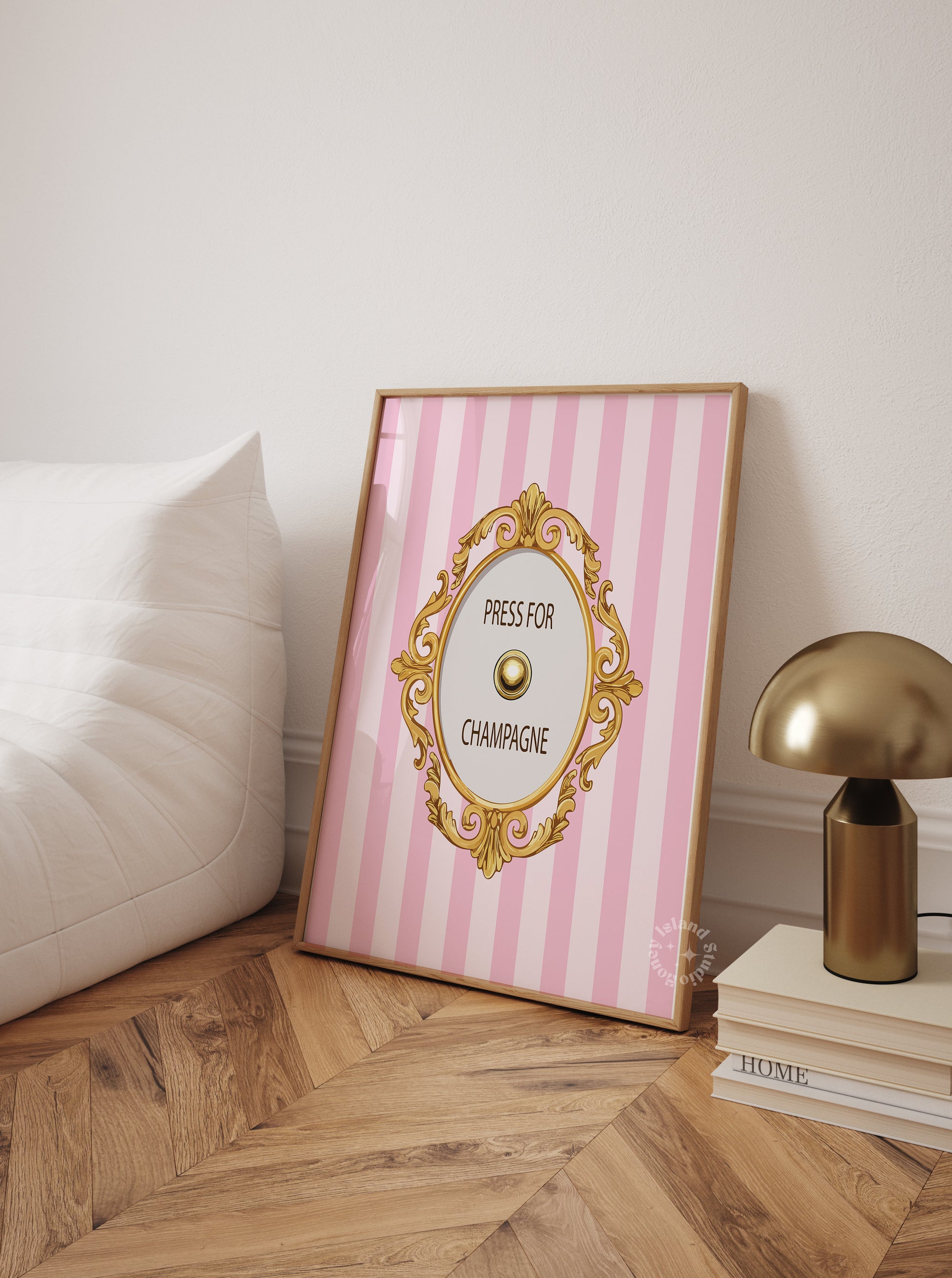 Framed pink and white striped poster with gold decorative elements on a wooden floor.