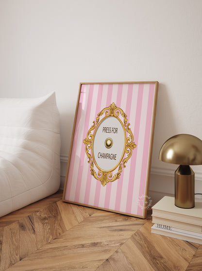 Framed pink and white striped poster with gold decorative elements on a wooden floor.