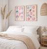 bedroom decorated with two wall art frames featuring coastal  coquette seashells, pink beige warm tones.