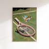 Framed artwork of a martini glass on a tennis racket with a tennis court background.