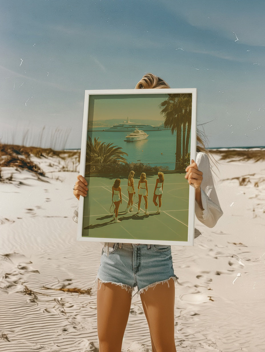 Person holding a framed artwork of women on a beach with palm trees and a boat in the background.